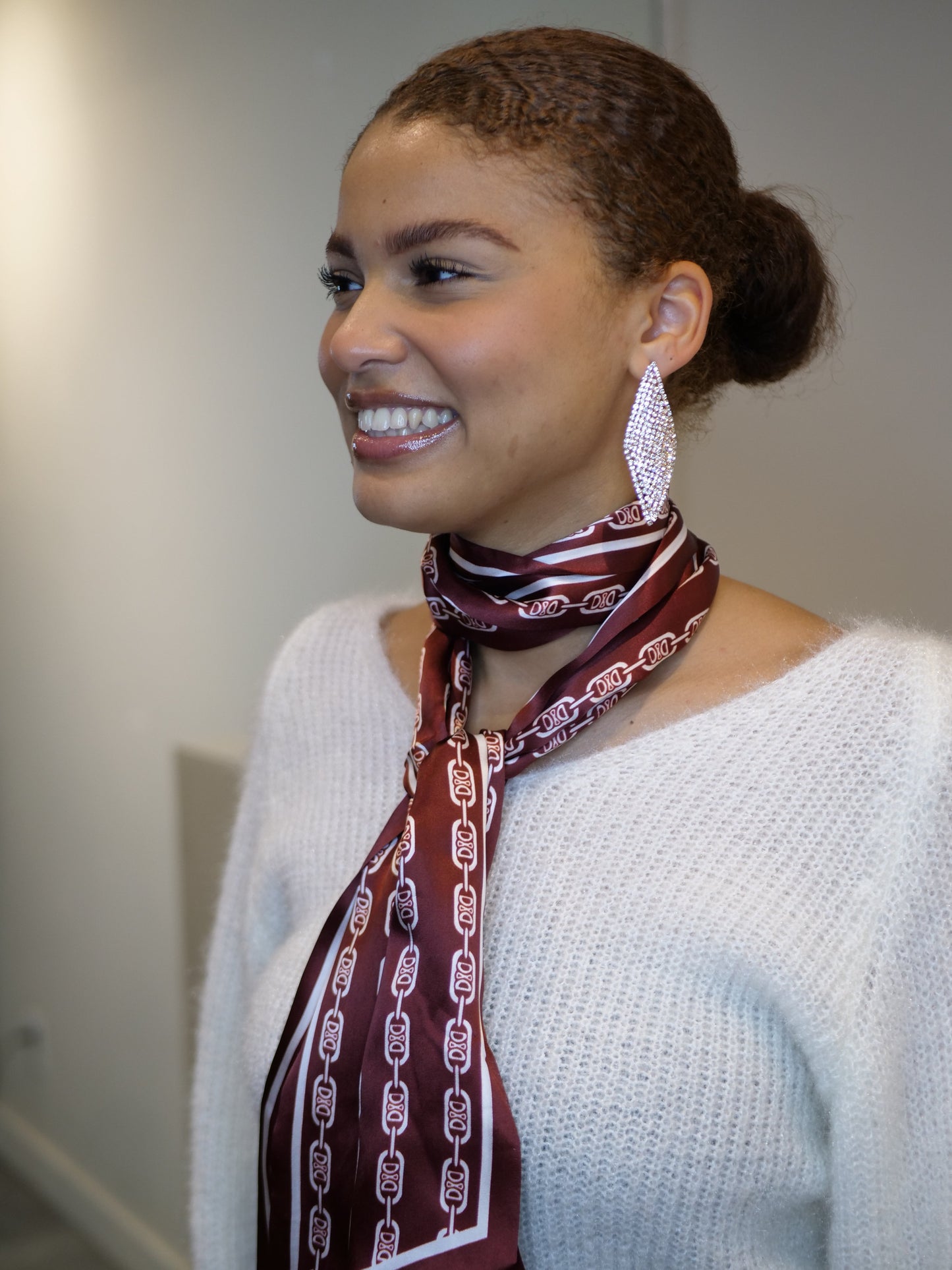 Boucles d'oreilles pendantes en forme de diamant, argentées et serties de cristaux.