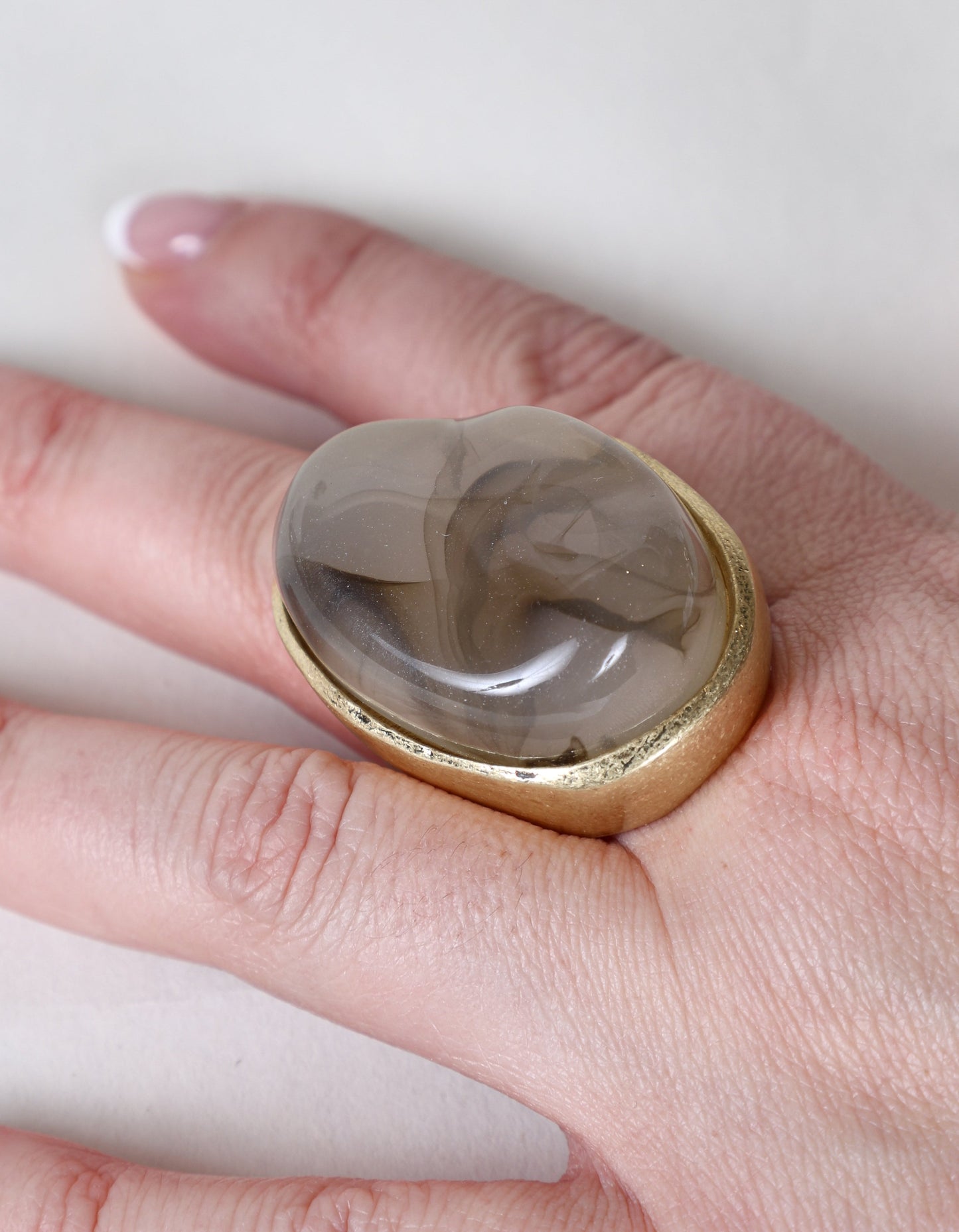Bague imposante ornée d'une pierre tourbillonnante grise et dorée